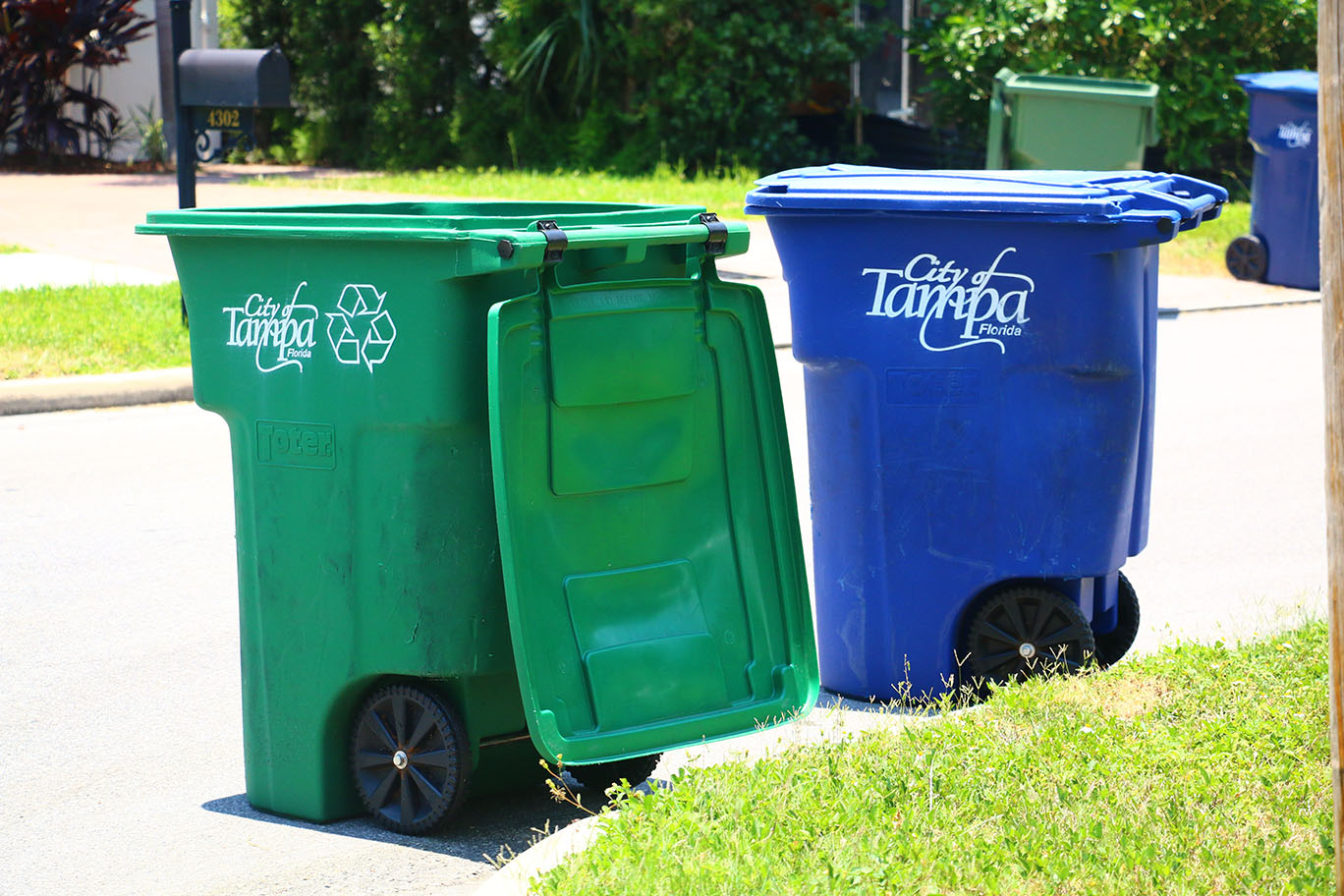 Green recycling cart and blue trash cart curbside