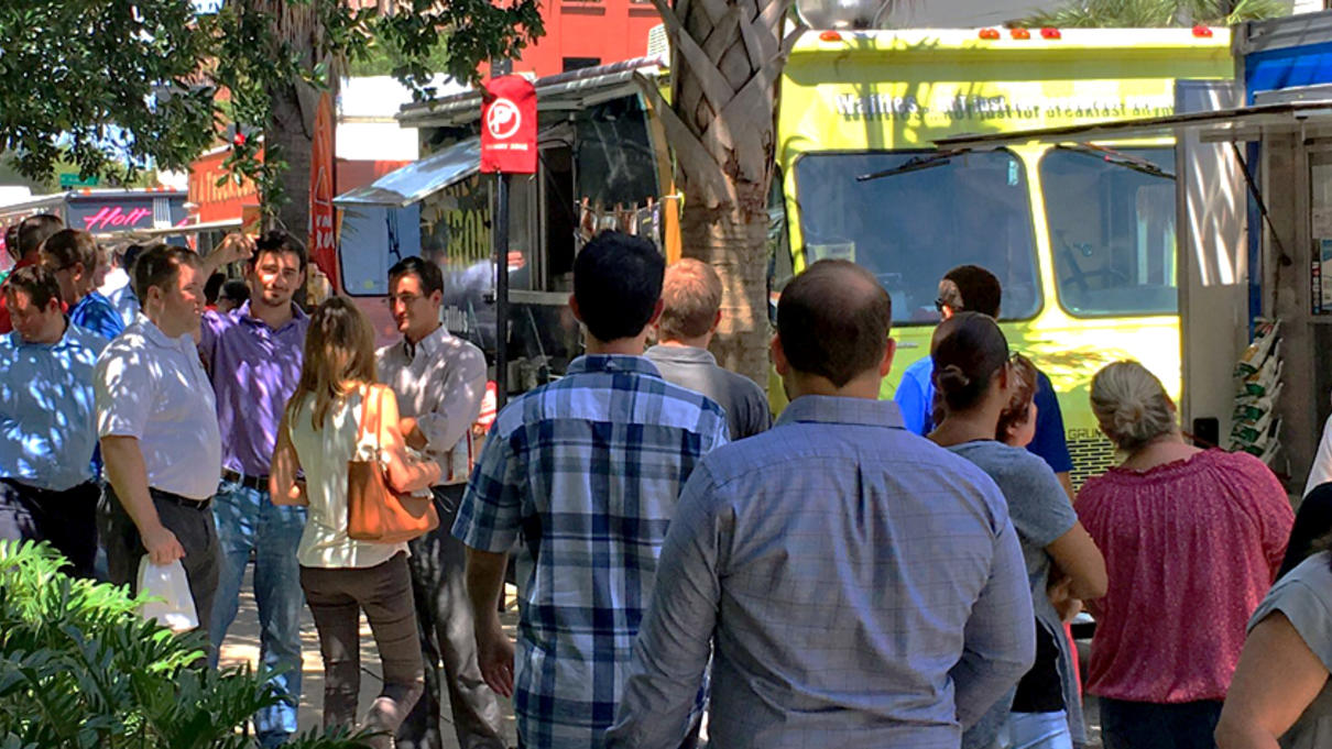 People standing in line in front of food trucks